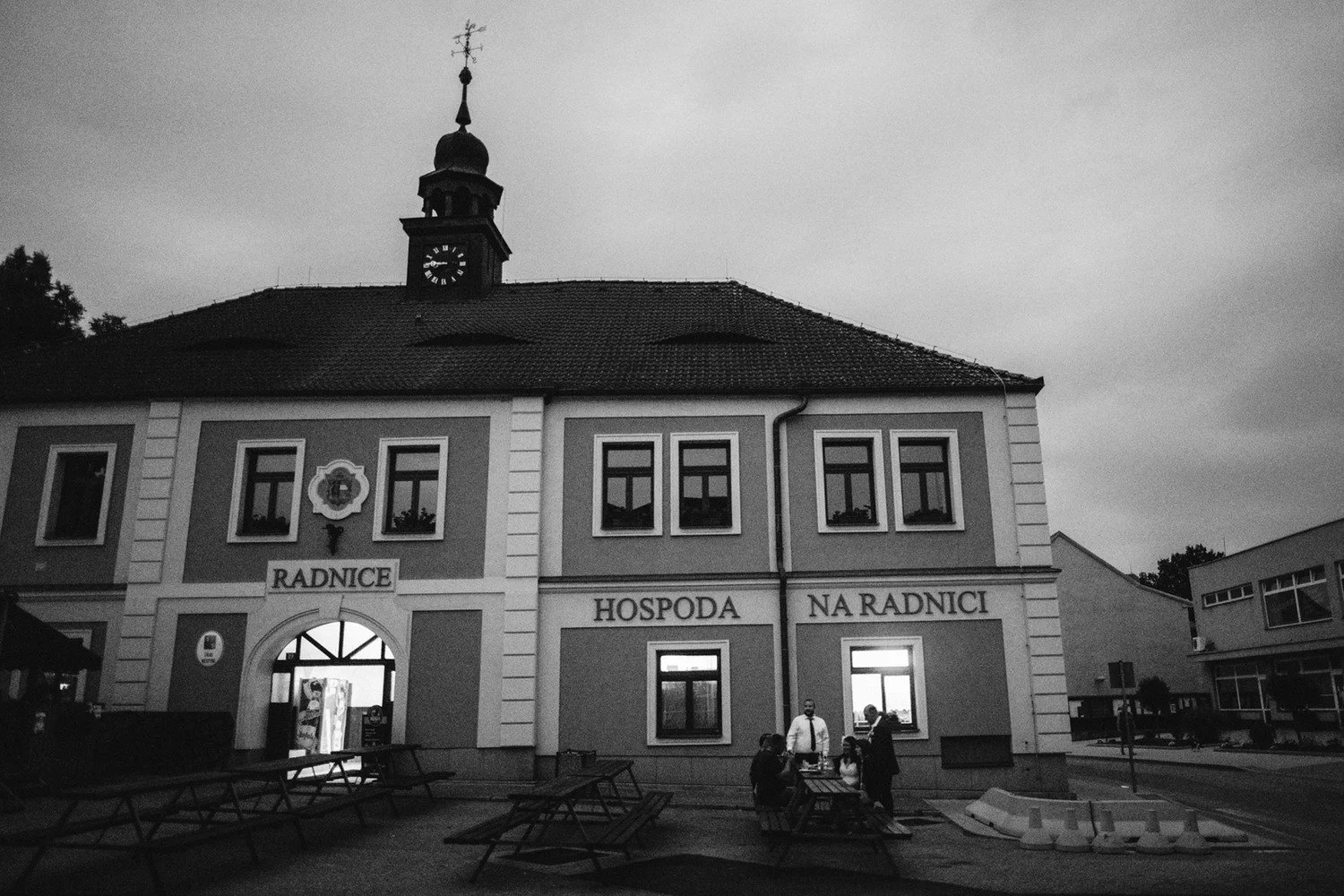 Černobílý večerní pohled na budovu hospody Na Radnici.