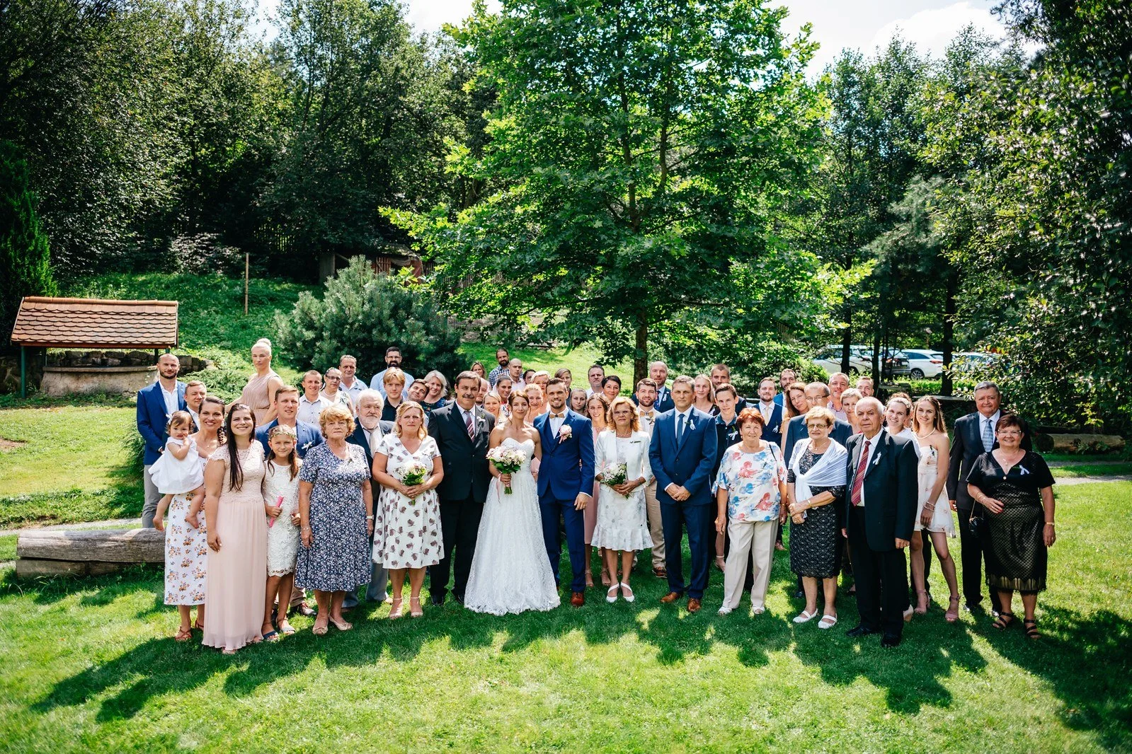 Široká skupinová fotografie před budovou mlýna.