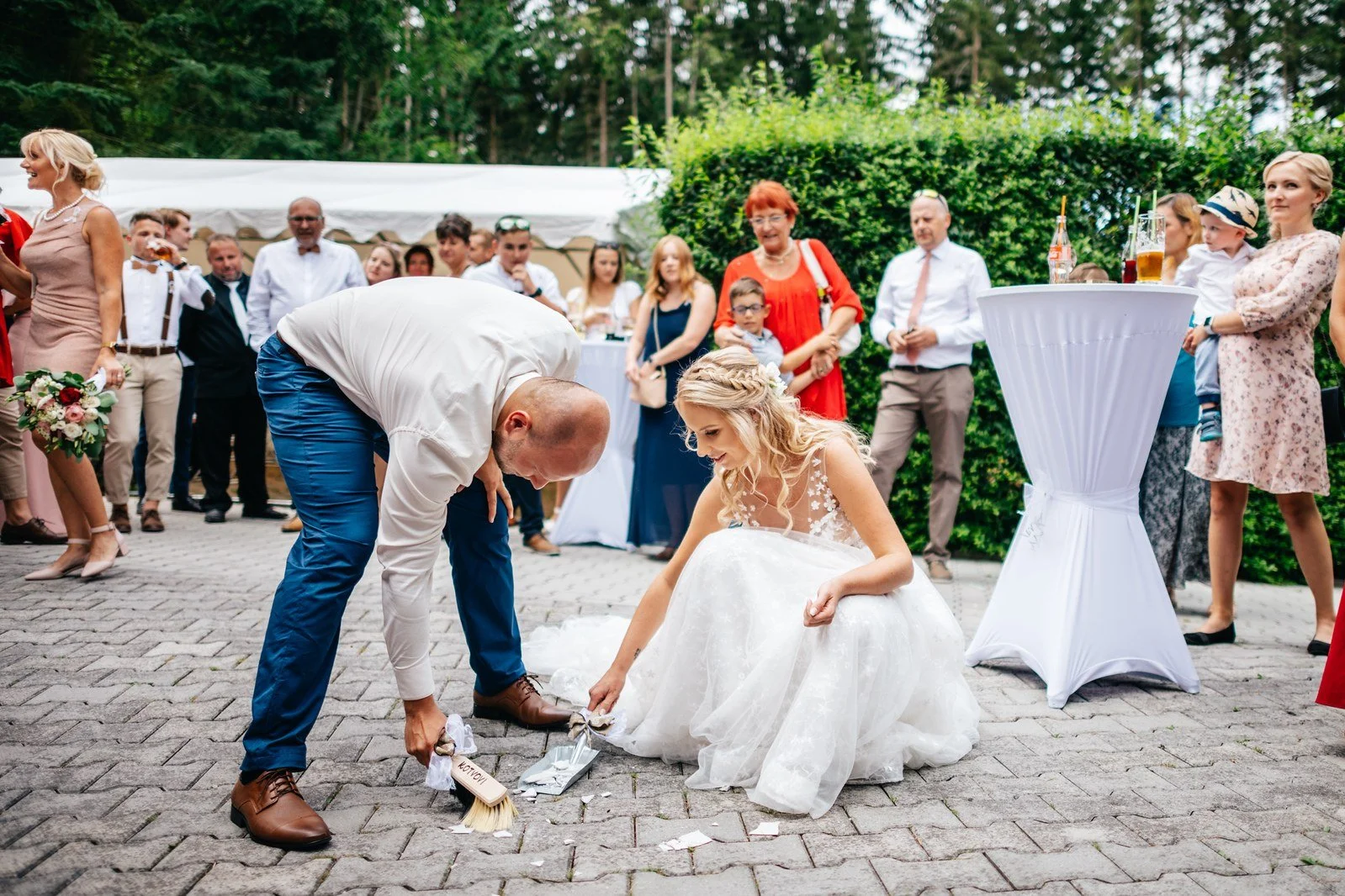 Dvojice společně uklízí střepy na terase.