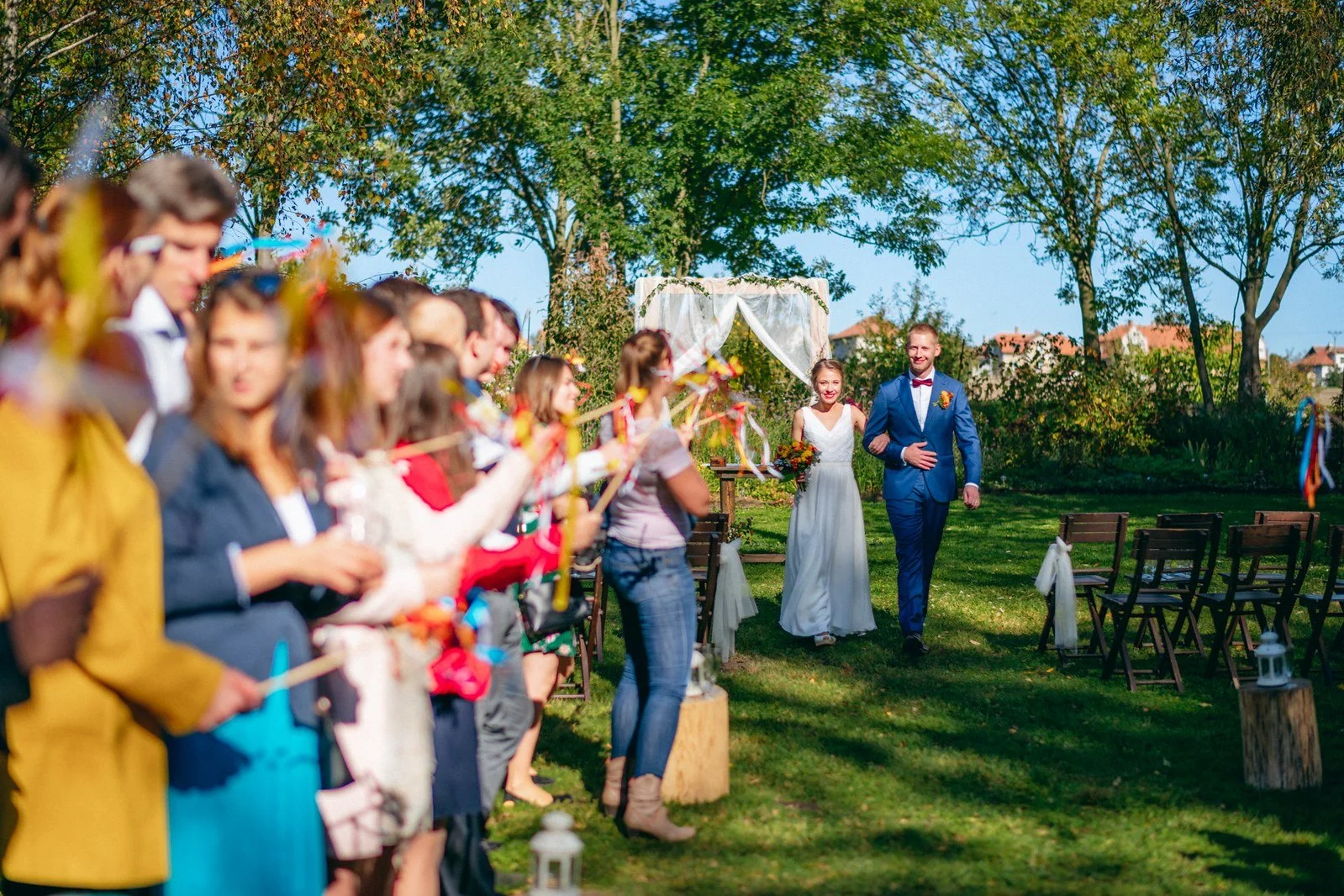 Dvě řady lidí vytvářejí barevný koridor a připravují následující akci.