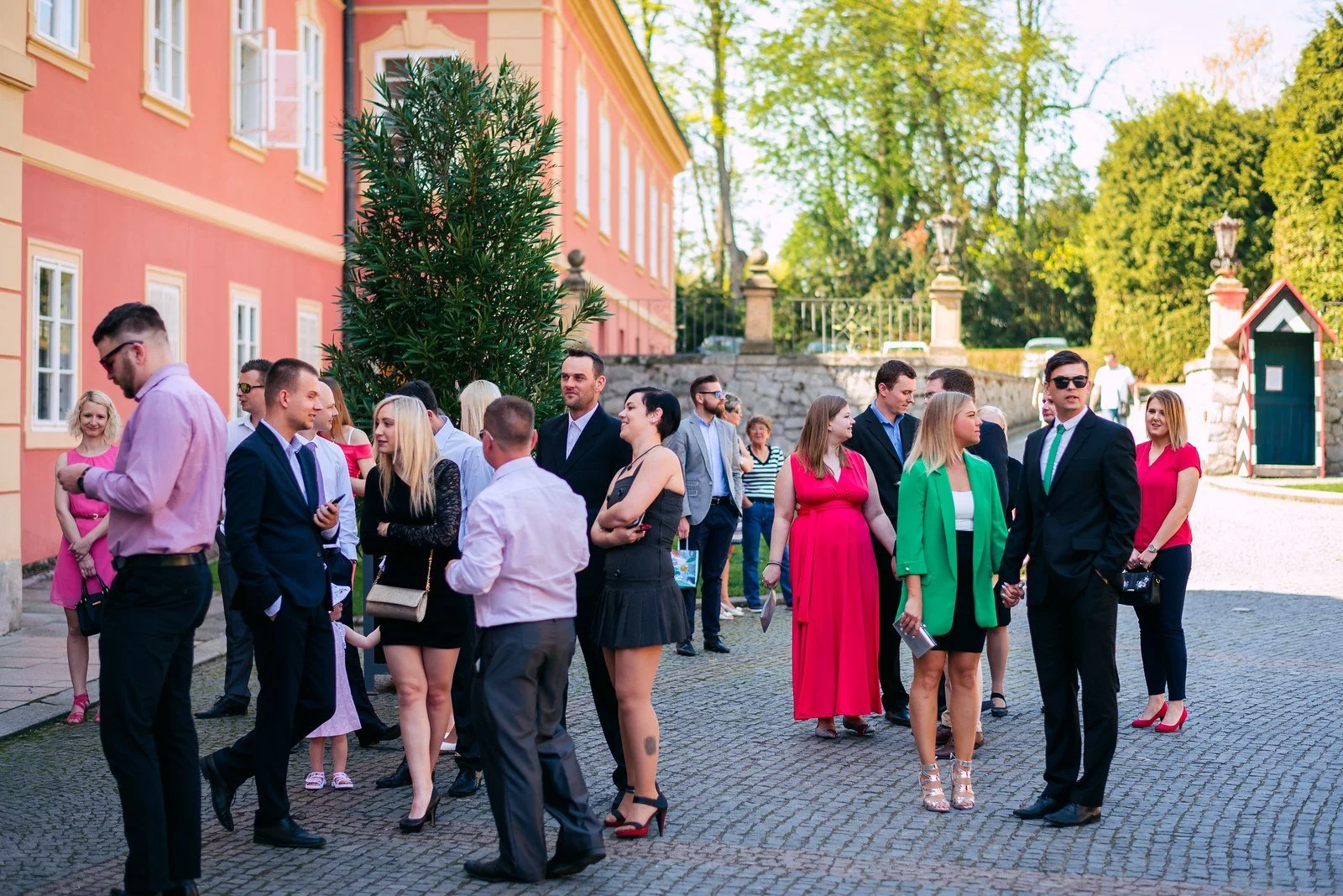 Řada svatebních hostů čeká před začátkem obřadu na Zámku Dobříš.