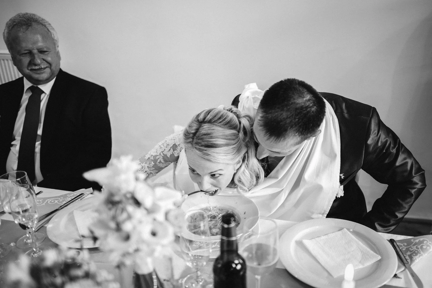 Černobílý záběr Jitky a Lukáše skloněných ke společnému talíři pod bílou látkou.