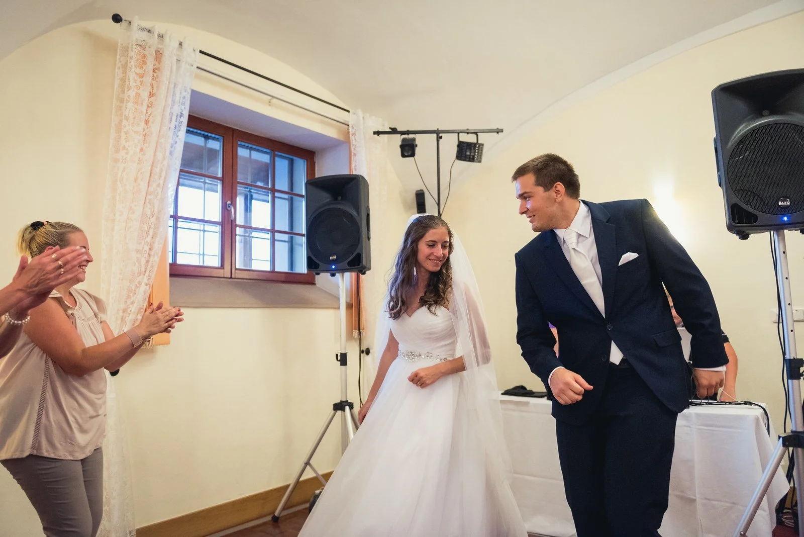 Dvojice stojí proti sobě uprostřed místnosti během pozdního programu, obklopená přihlížejícími.