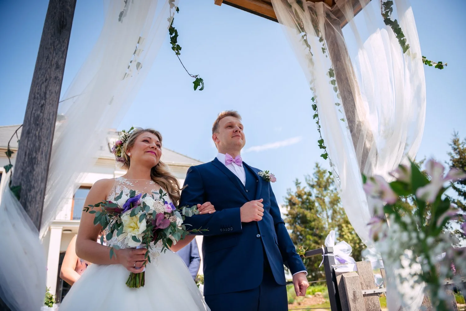 Nevěsta s otcem vstupují pod obřadní altán během svatby Roman a Sára v Penzionu a Pivovaru Nový Rybník u Obořiště.