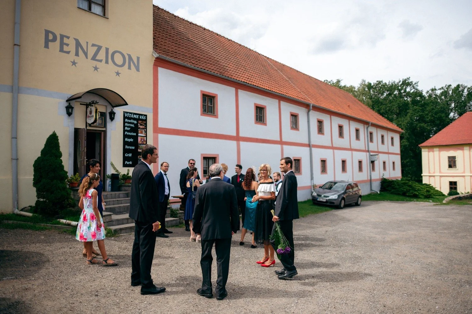 Hosté se scházejí před budovou penzionu.