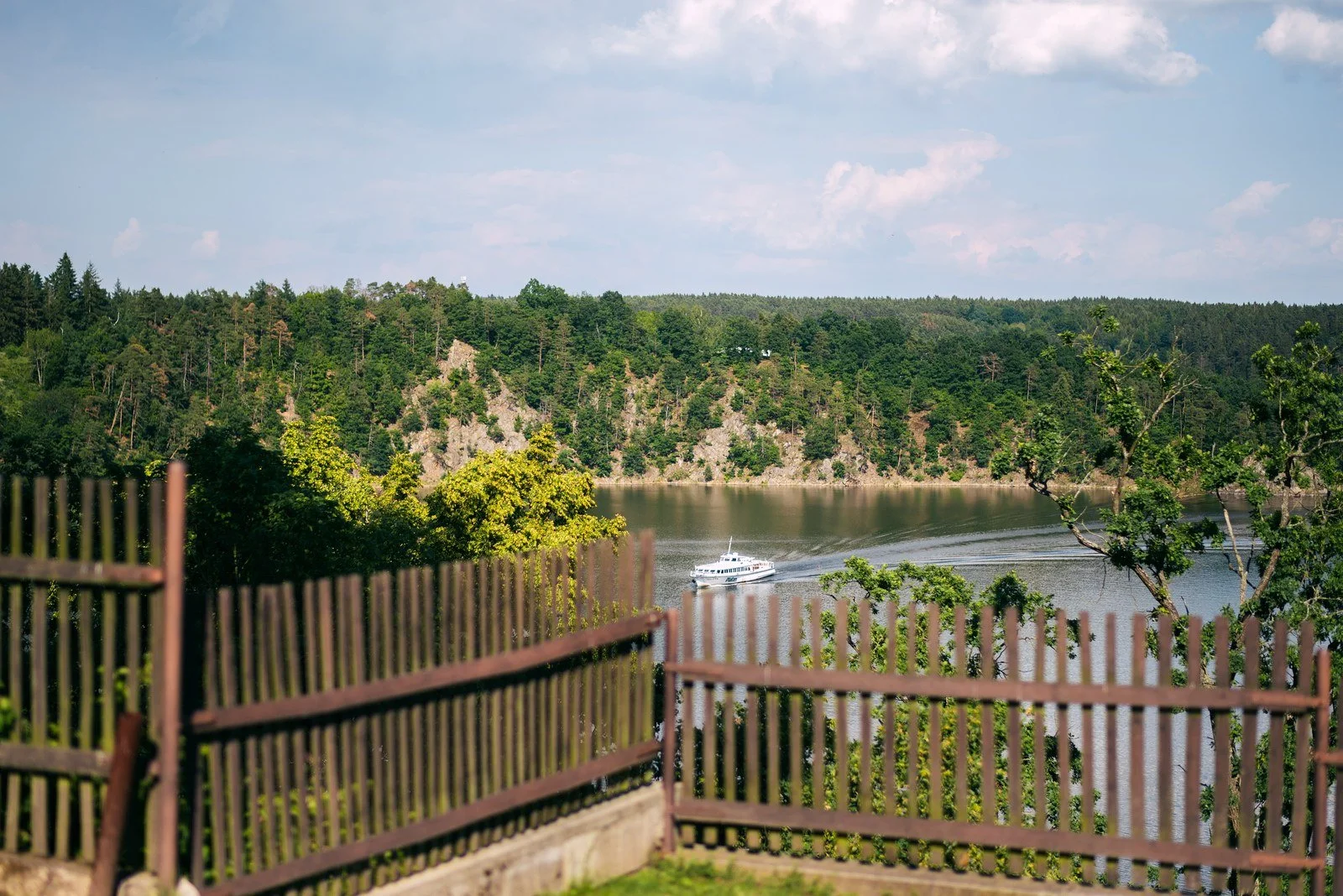 Terasa se zábradlím otevírá široký pohled přes jezero k protějšímu břehu.
