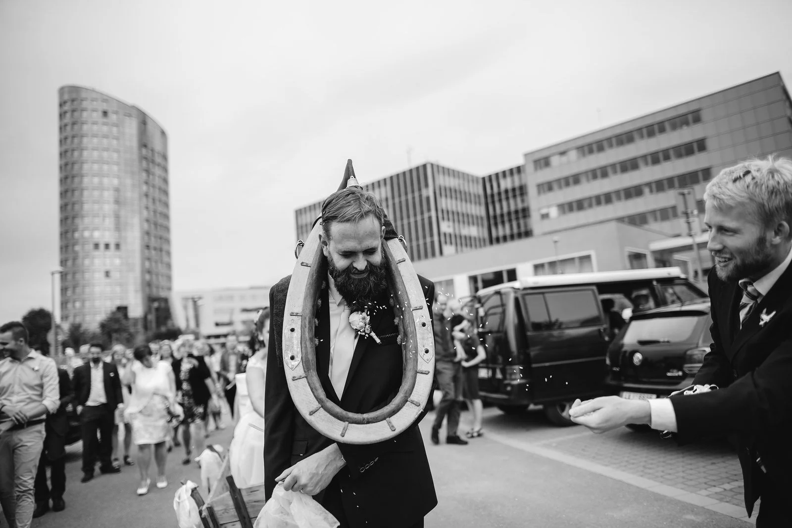 Černobílý záběr zachycuje živou venkovní hru obklopenou přihlížejícími lidmi.