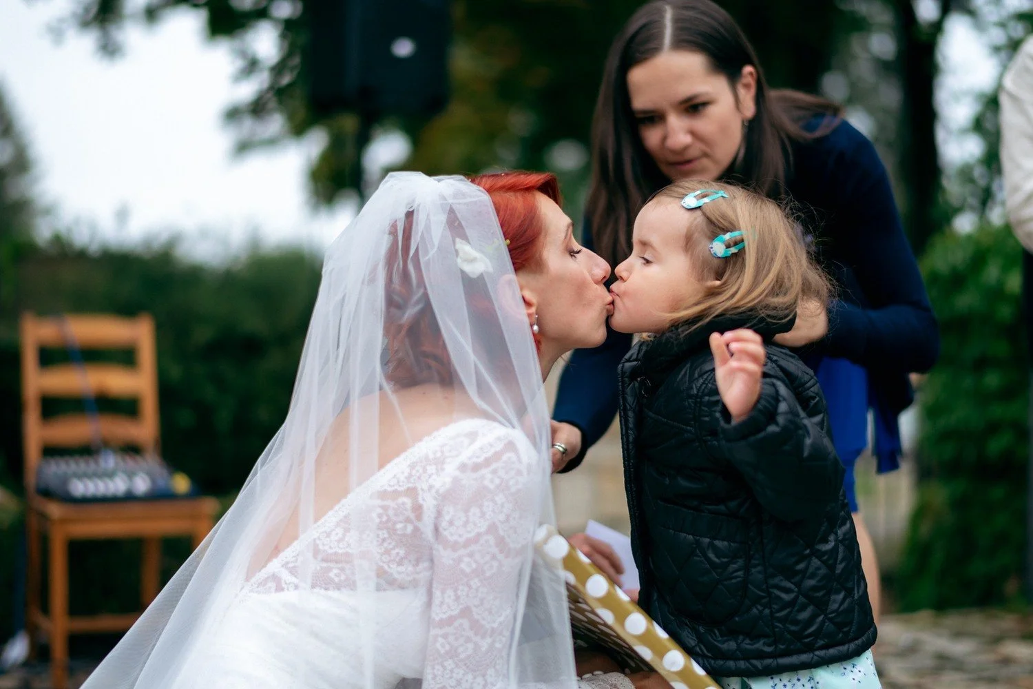 Martina se sklání k malé dívce s modrou bublifukovou hůlkou.