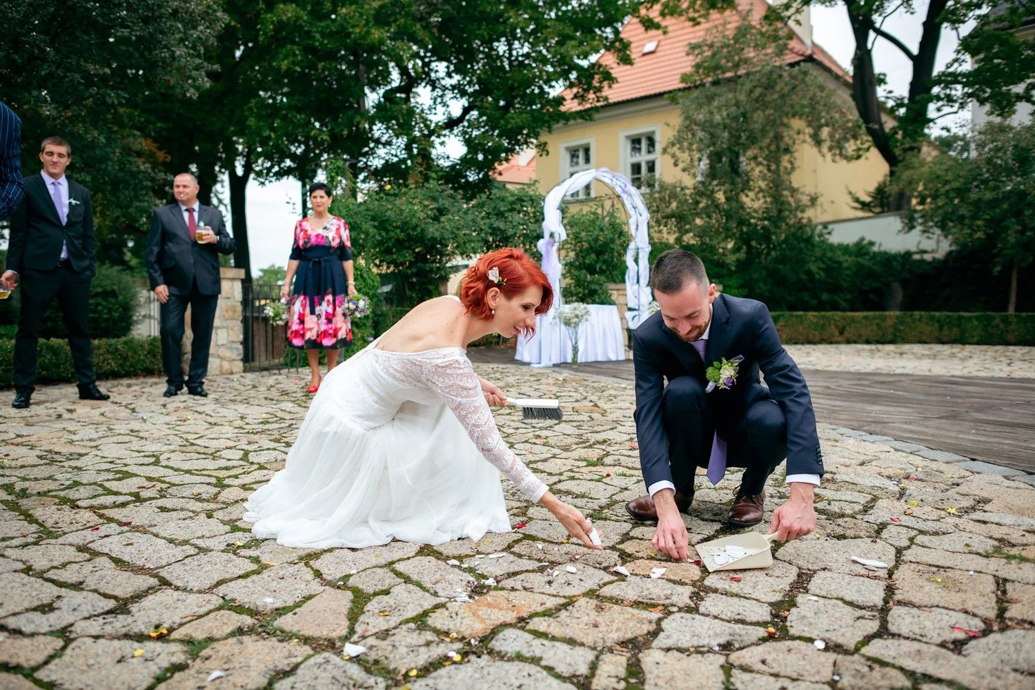Martina s Lukášem se sklánějí k dlažbě u obřadního oblouku.