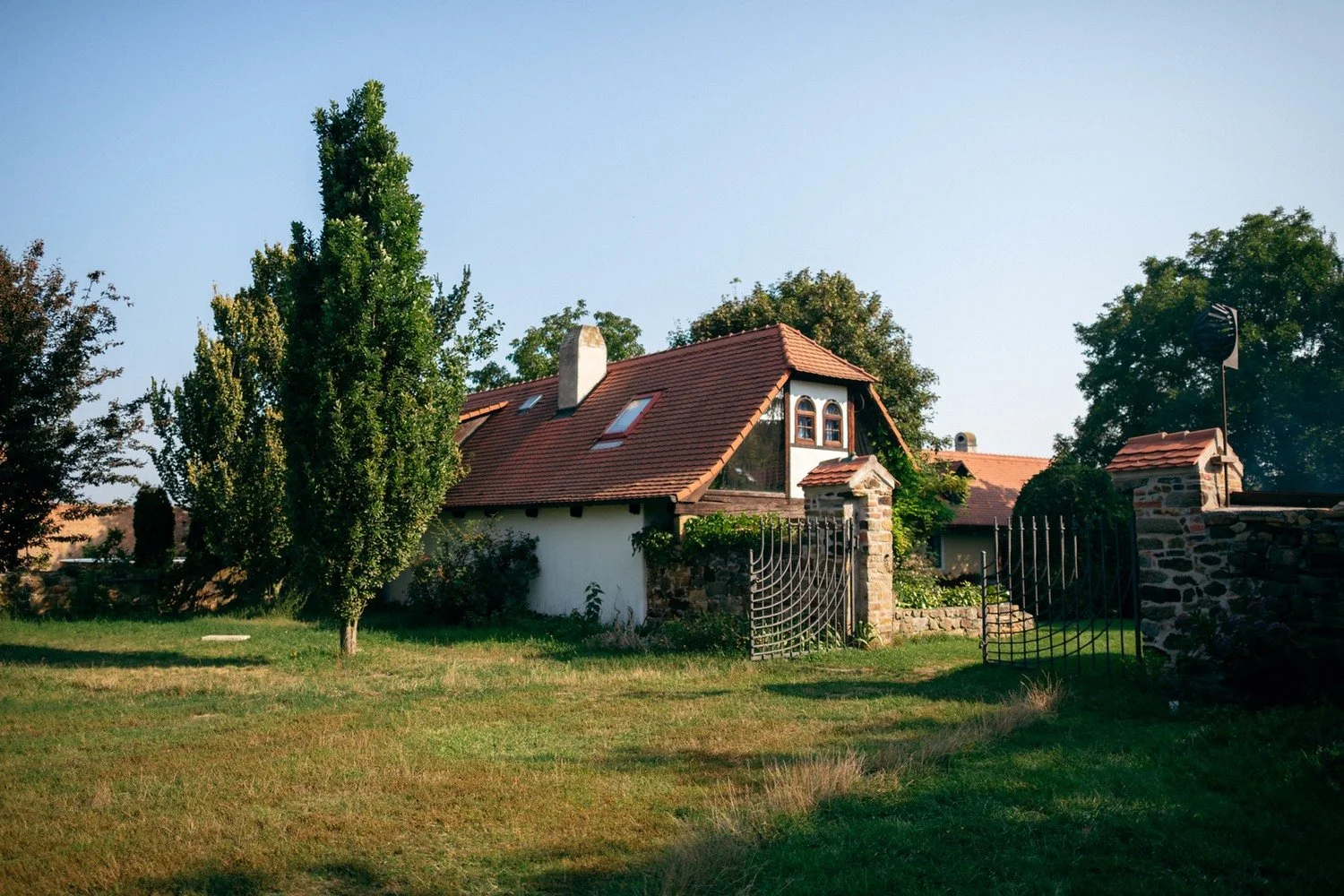 Pohled na venkovský dům a zahradu statku za slunečného dne