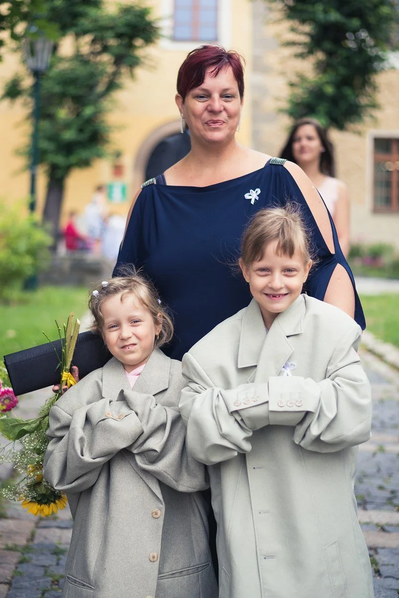 Dítě ve slavnostním oblečení čeká venku před obřadem.