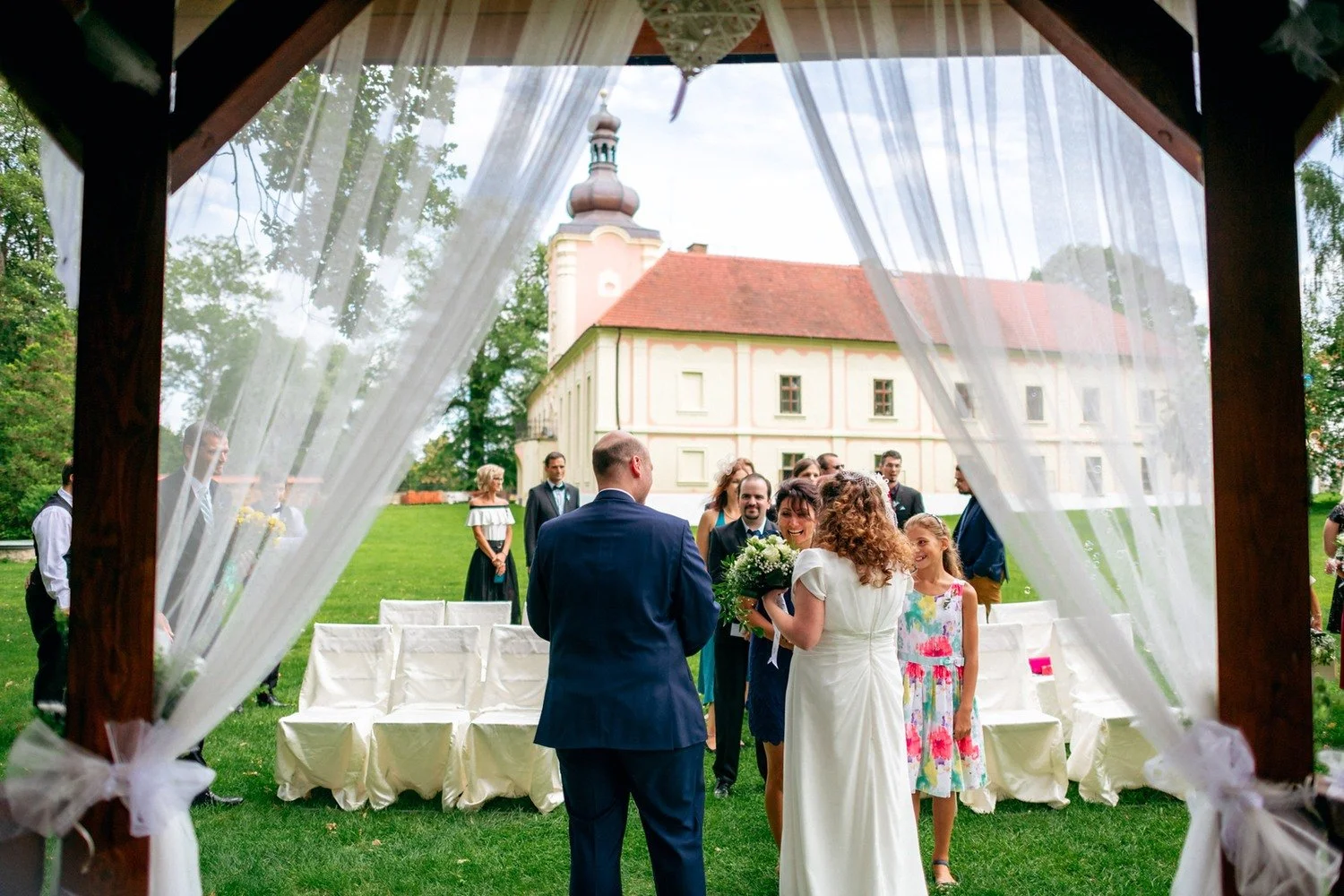 Pár odchází od altánu uličkou mezi hosty.