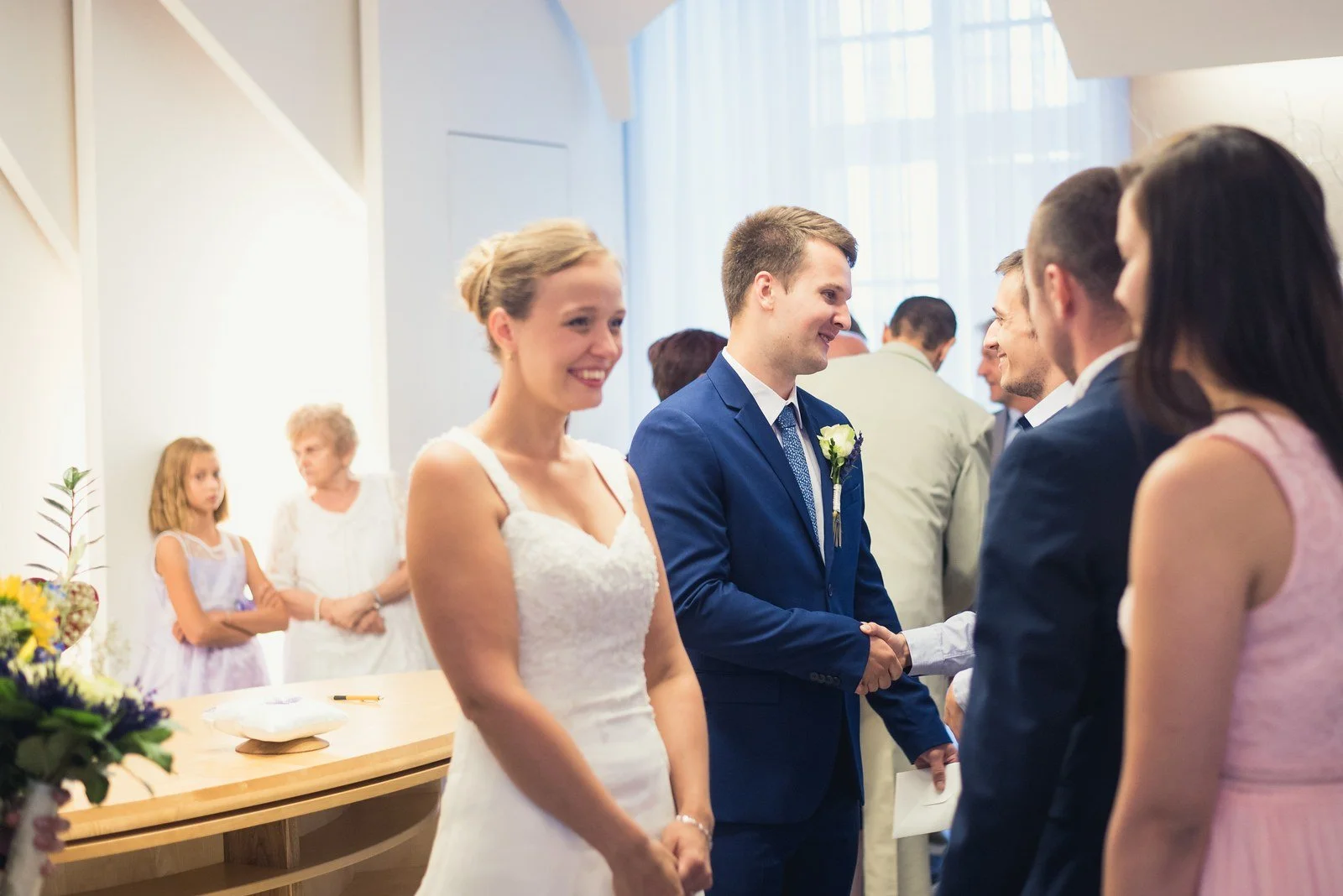 Hosté tleskají novomanželům v obřadní síni.