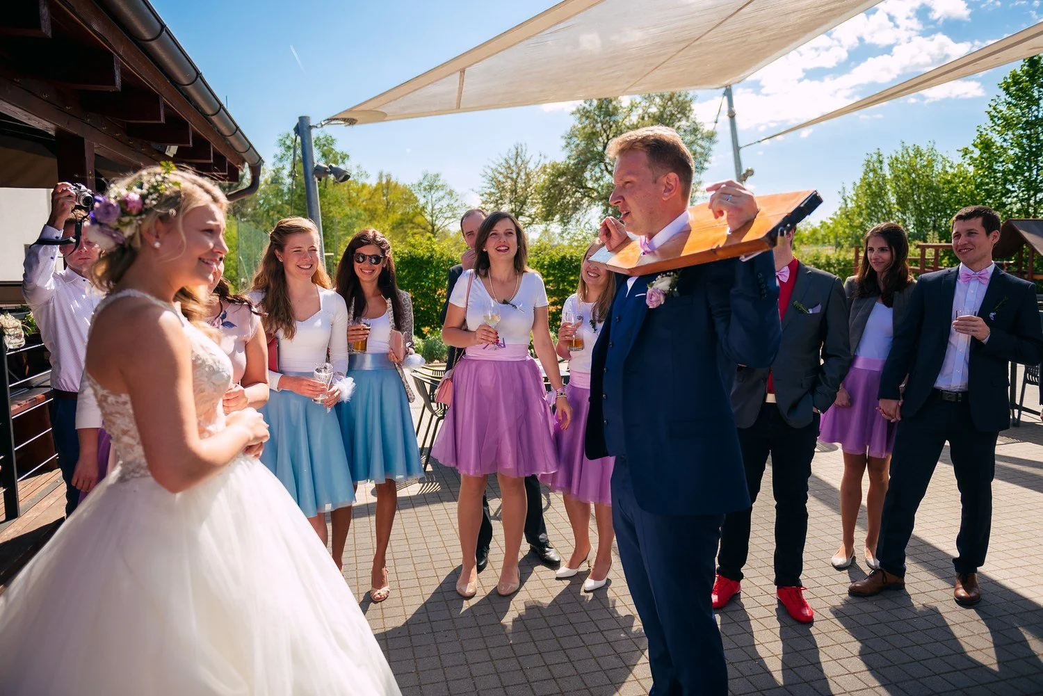 Sára a Roman společně drží dřevěný chomout při svatební hře.