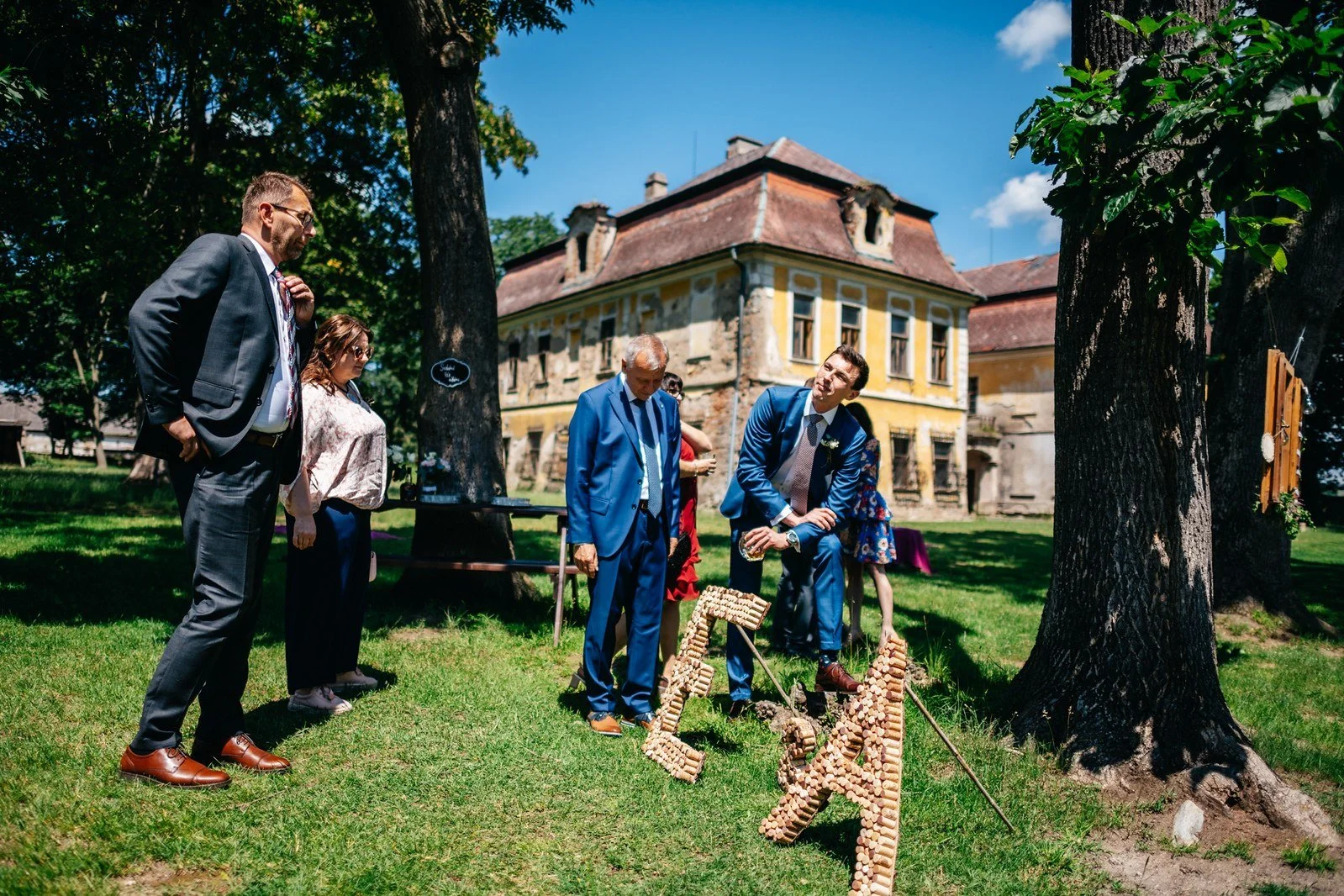 Hosté přicházejí zahradou k historické budově.