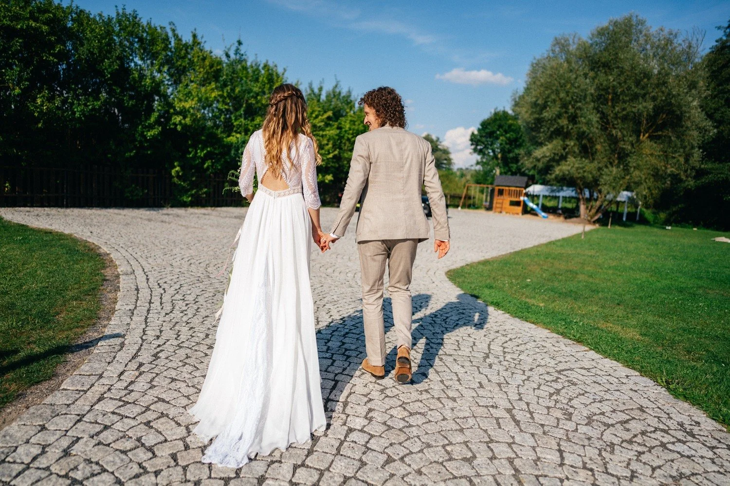 Anička a Norbert odcházejí ruku v ruce po dlážděné cestě