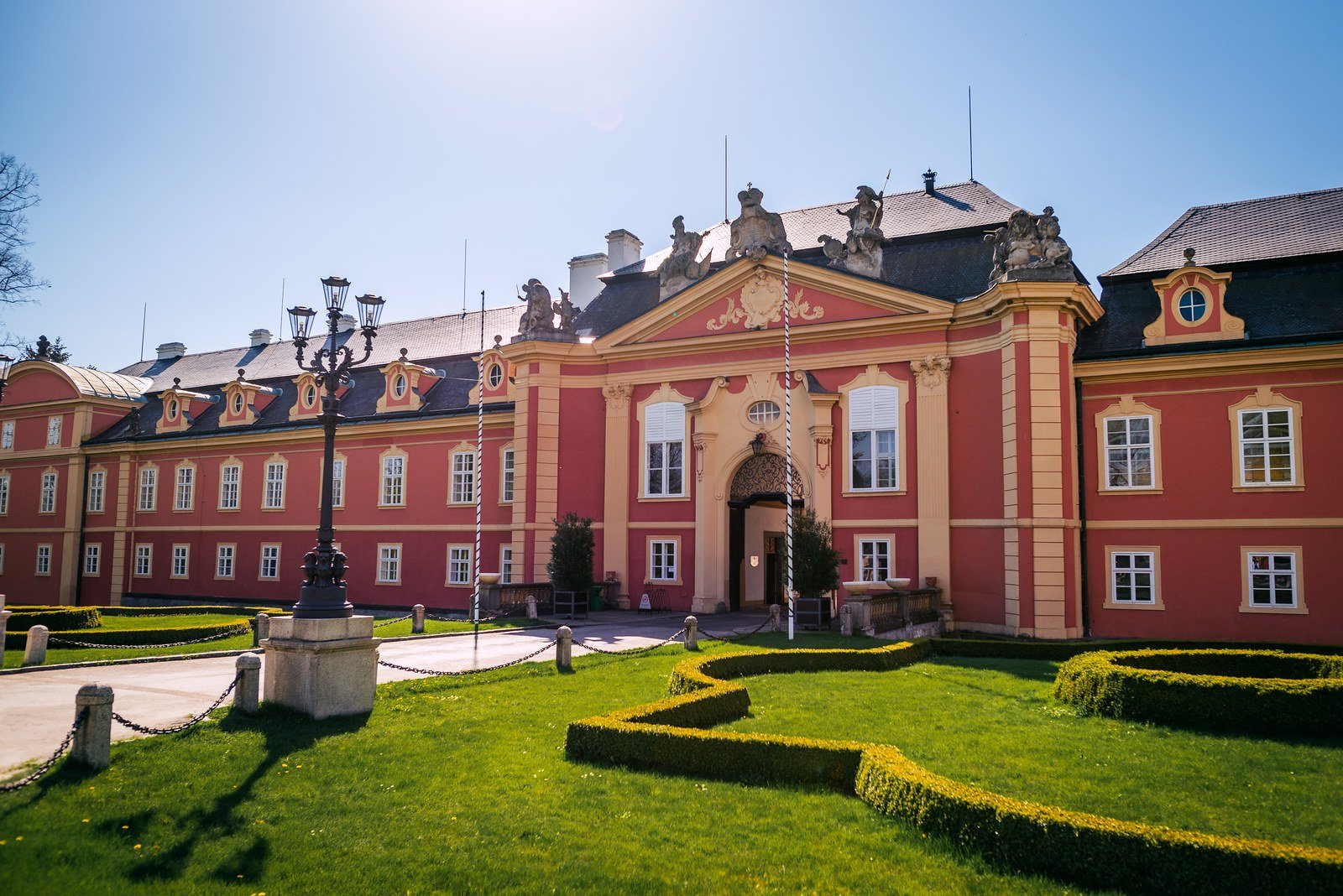 Široký pohled na exteriér Zámku Dobříš a přilehlou zahradu.