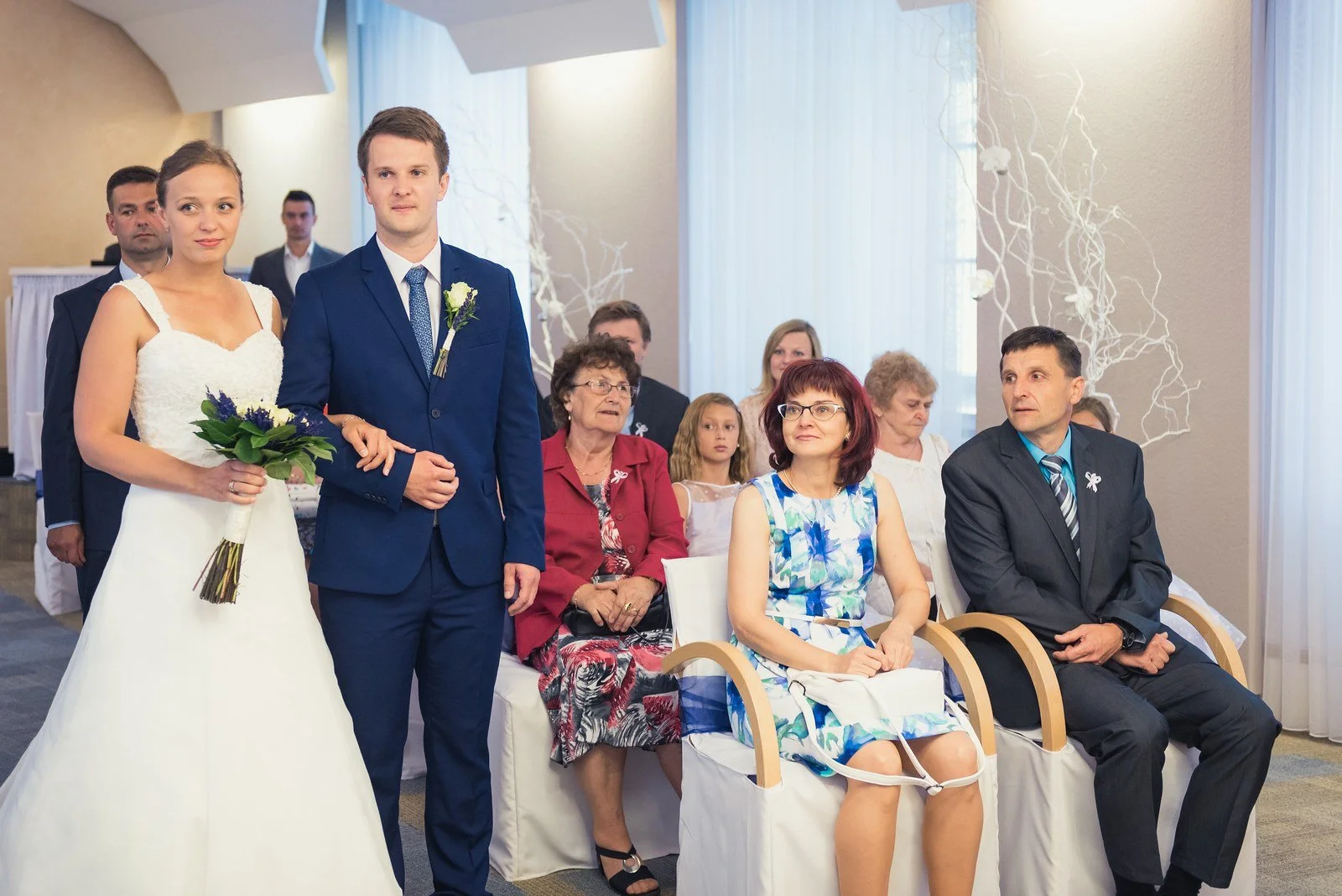 Širší pohled na pár, oddávajícího a svědky při obřadu.