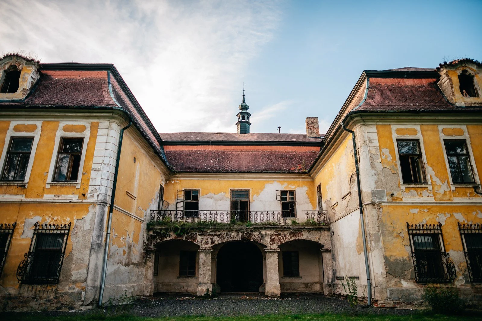 Vnitřní nádvoří historického areálu se žlutými fasádami.