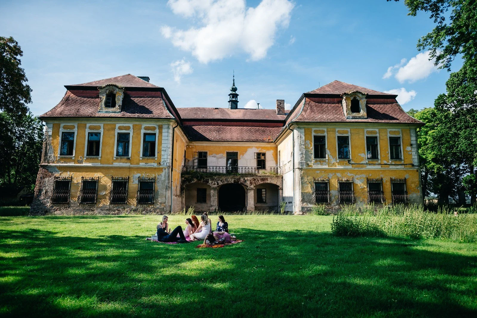 Historická budova Penzionu Smolotel s rozlehlým trávníkem.