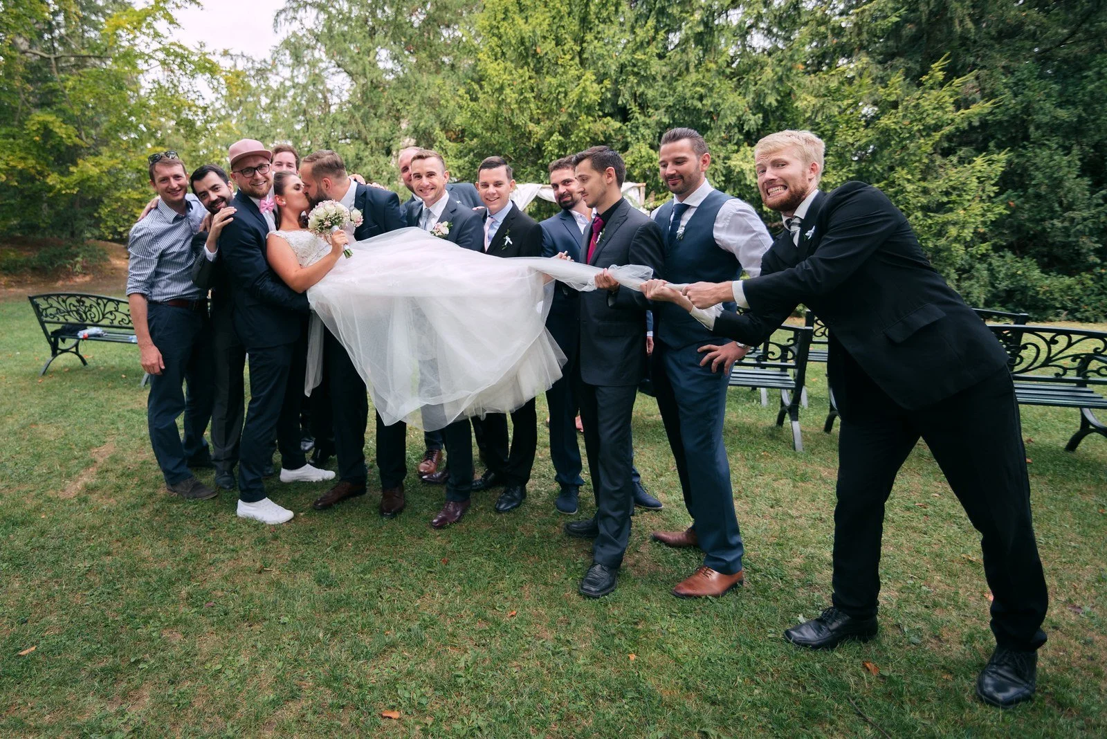 Dvě skupiny mužů proti sobě napínají bílou látku při venkovní hře.