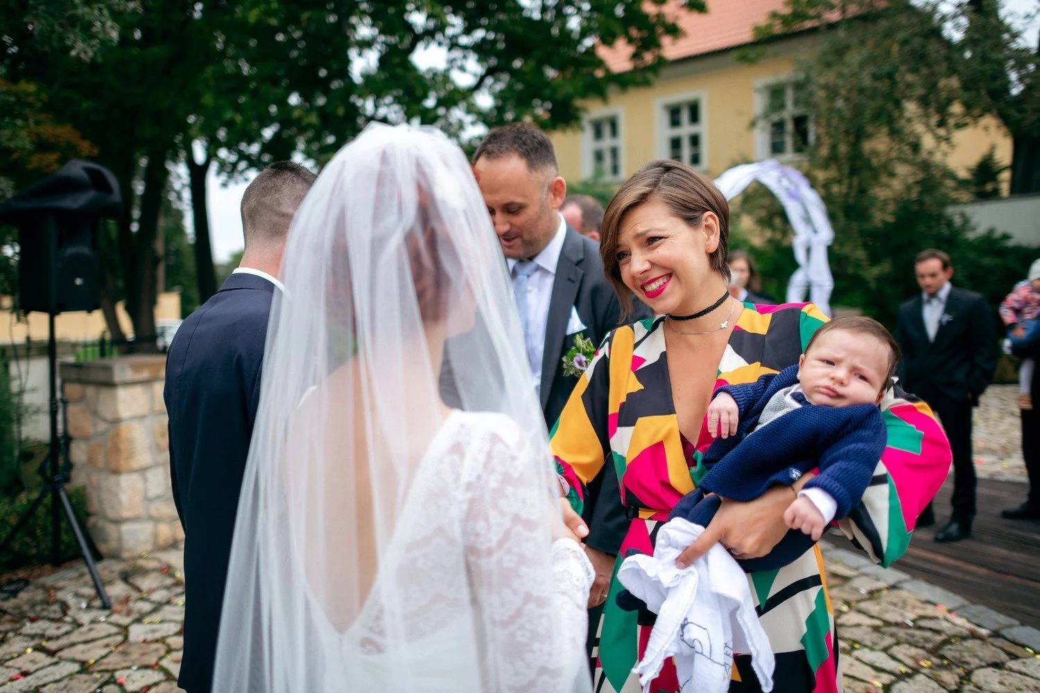 Martina hovoří se ženou, která drží spící miminko.