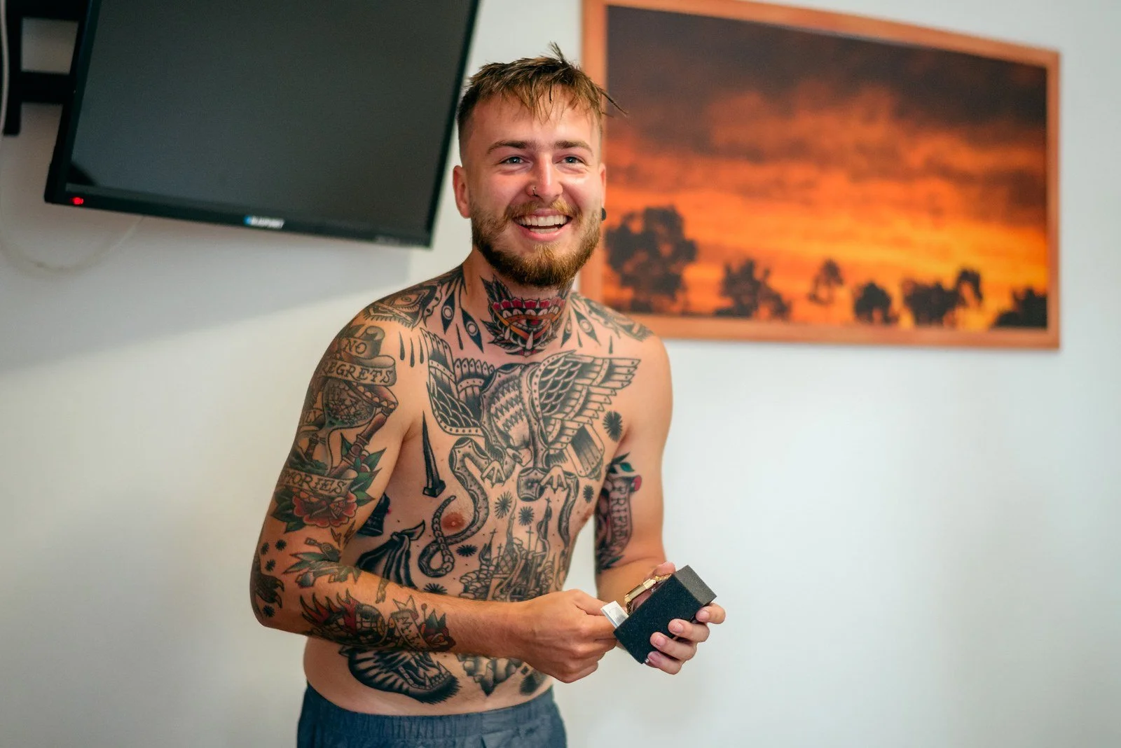 Klára si u okna nasazuje náušnici, zatímco v popředí leží kytice.