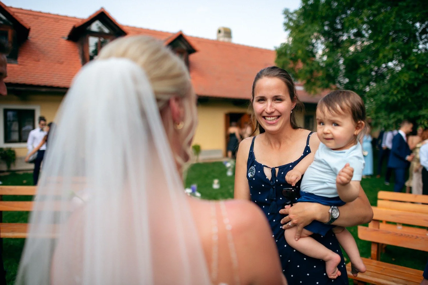Nevěsta sleduje usmívající se ženu s malým dítětem