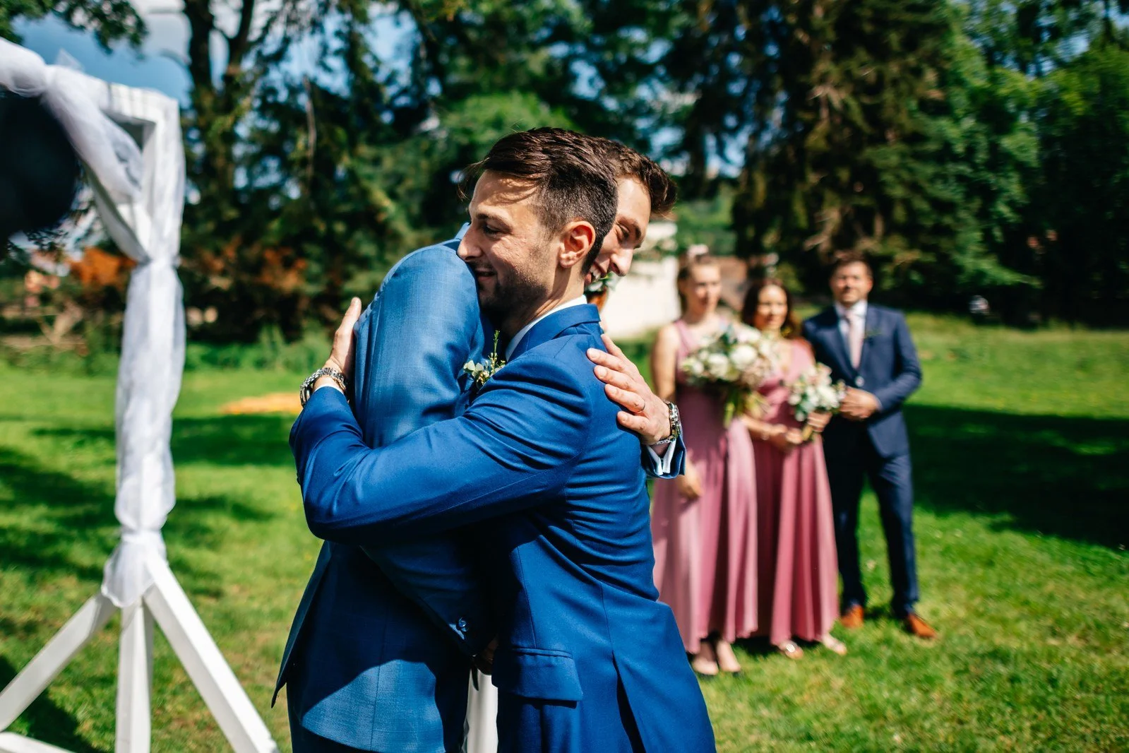 Dva muži se objímají během gratulací po obřadu.