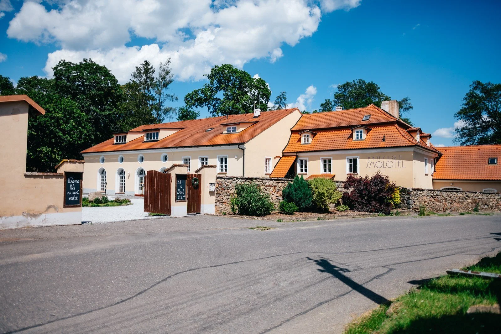 Areál Penzionu Smolotel s historickými budovami pod modrou oblohou.