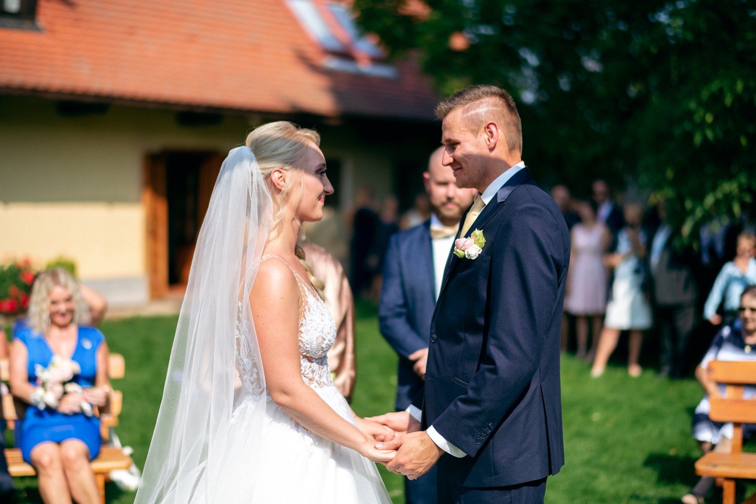 Detail páru držícího se za ruce před hosty