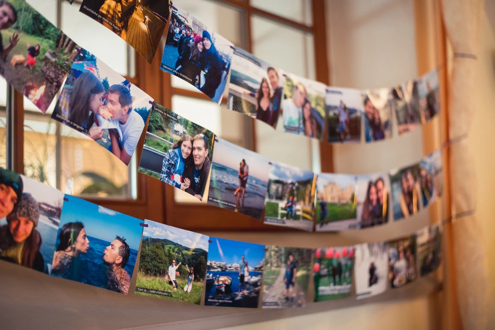 Stěna pokrytá mnoha malými fotografiemi přidává osobitý viditelný detail výzdoby.