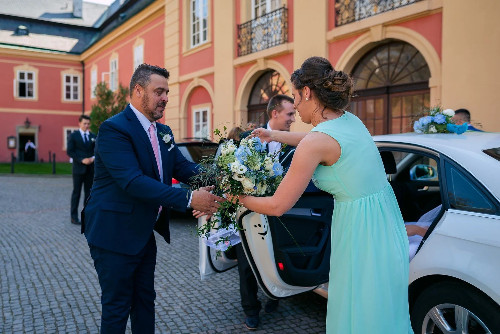 Příjezd před Zámek Dobříš s otevřeným autem a svatební kyticí.