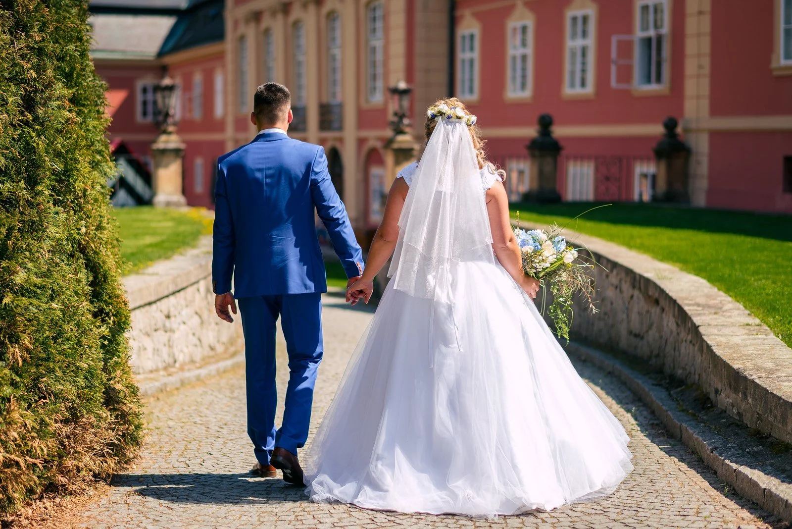 Nikola a David odcházejí společně po zahradní cestě.