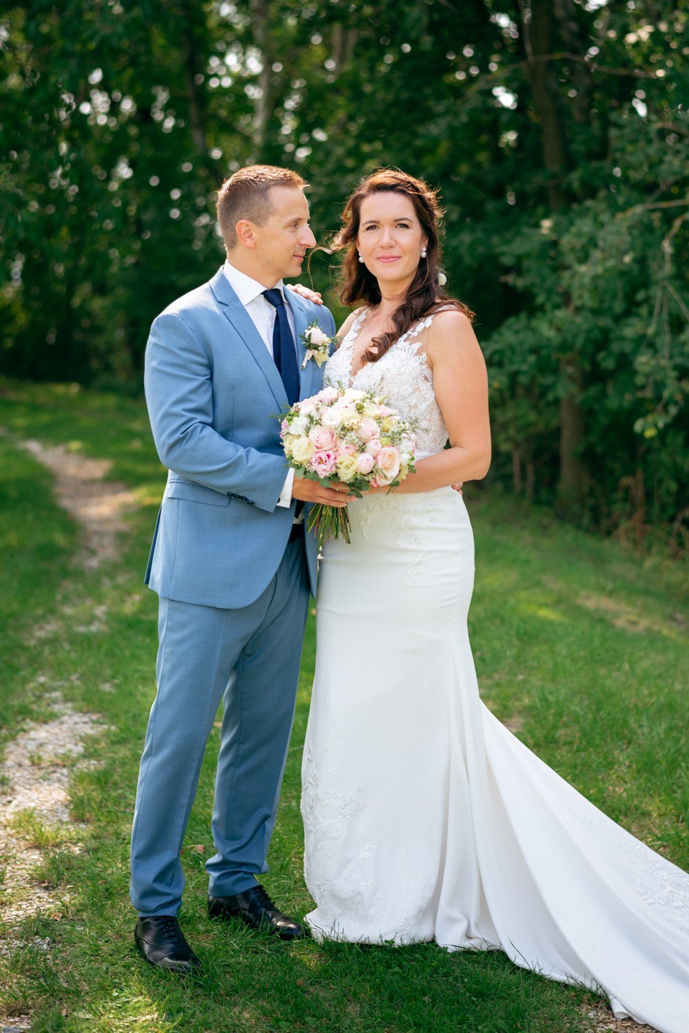 Vertikální portrét Káti a Jirky u stromu, oba hledí přímo do fotoaparátu.