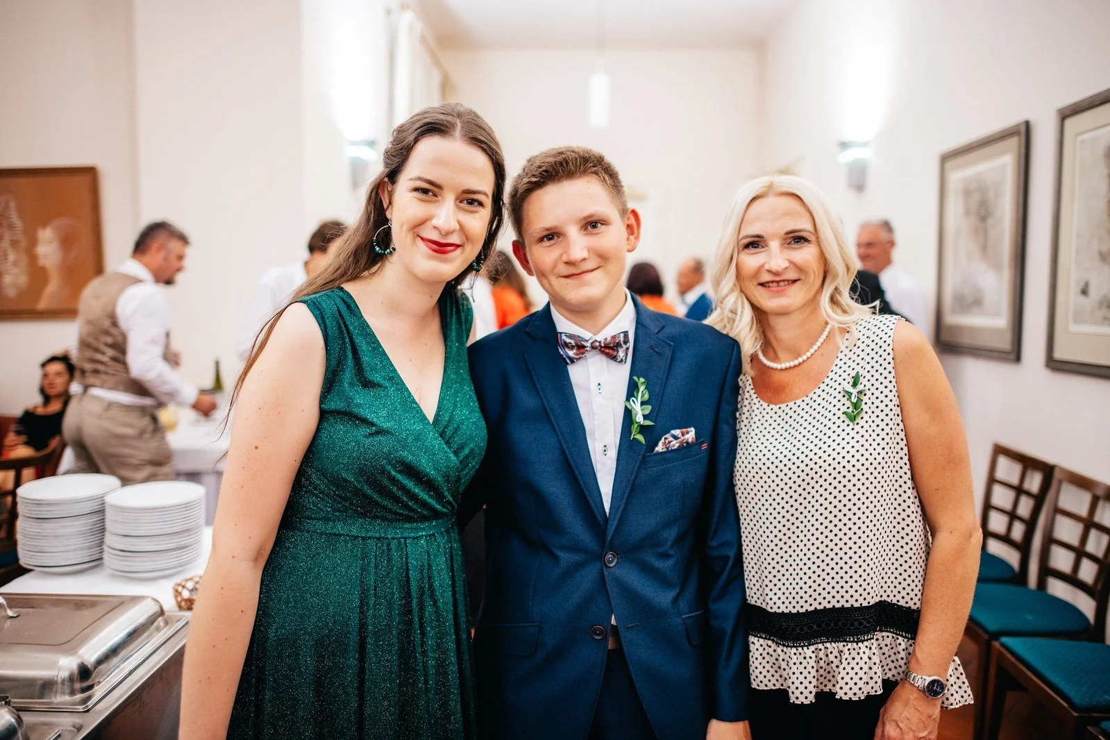 Skupina hostů pózuje těsně vedle sebe.
