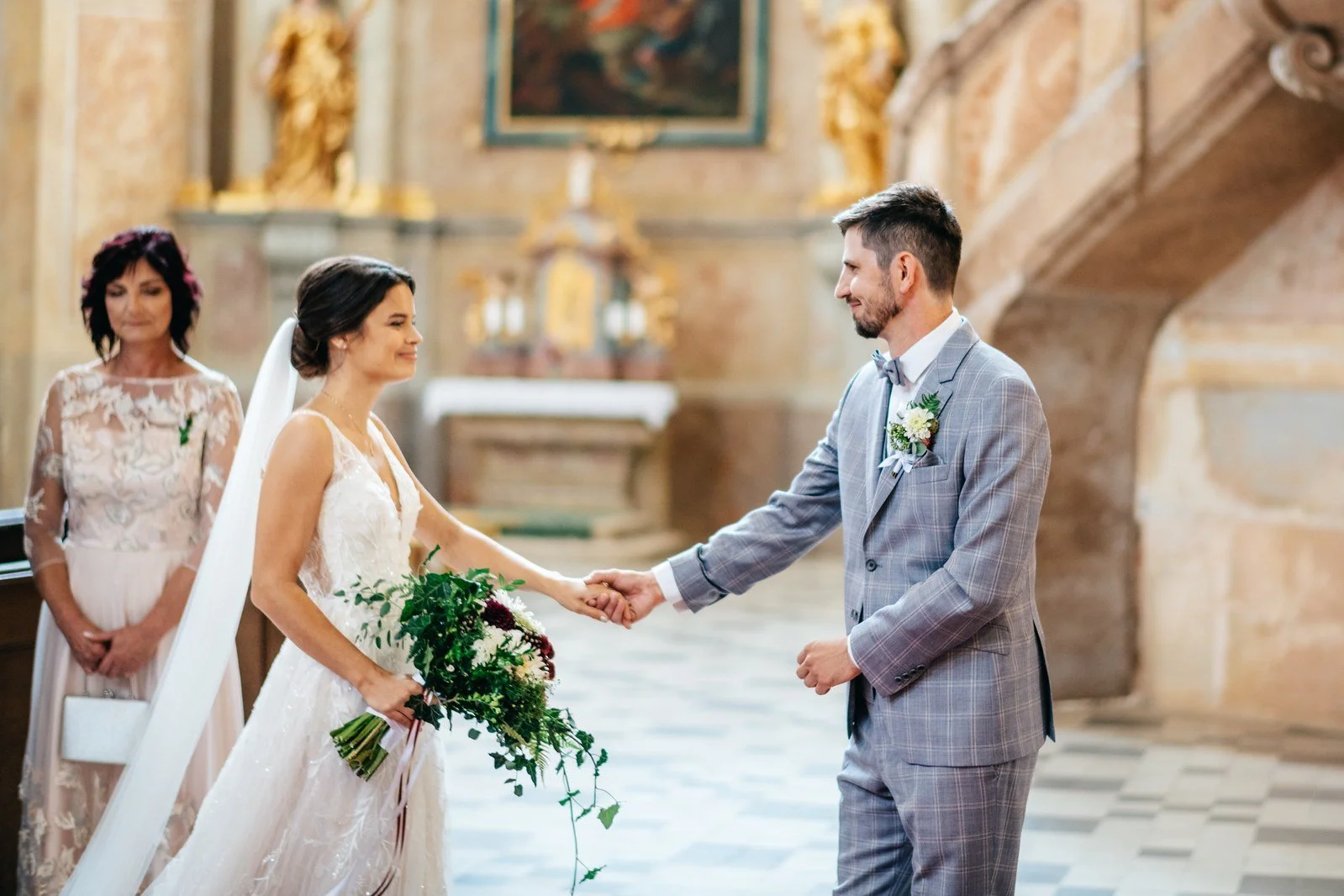 Dvojice stojí proti sobě před oltářem během obřadu.