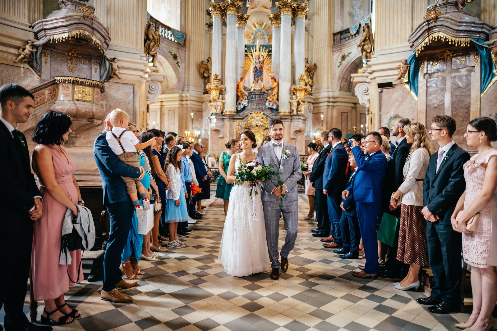 Odchod dvojice středem chrámové lodi.