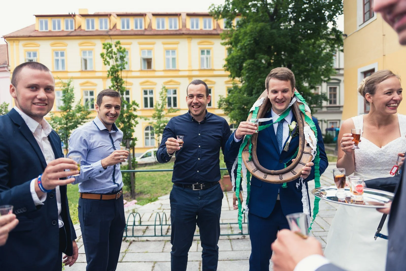 Hosté se smějí při společném svatebním zvyku venku.