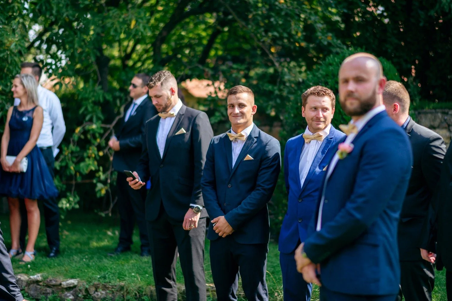 Ženich čeká se skupinou mužů u obřadního místa