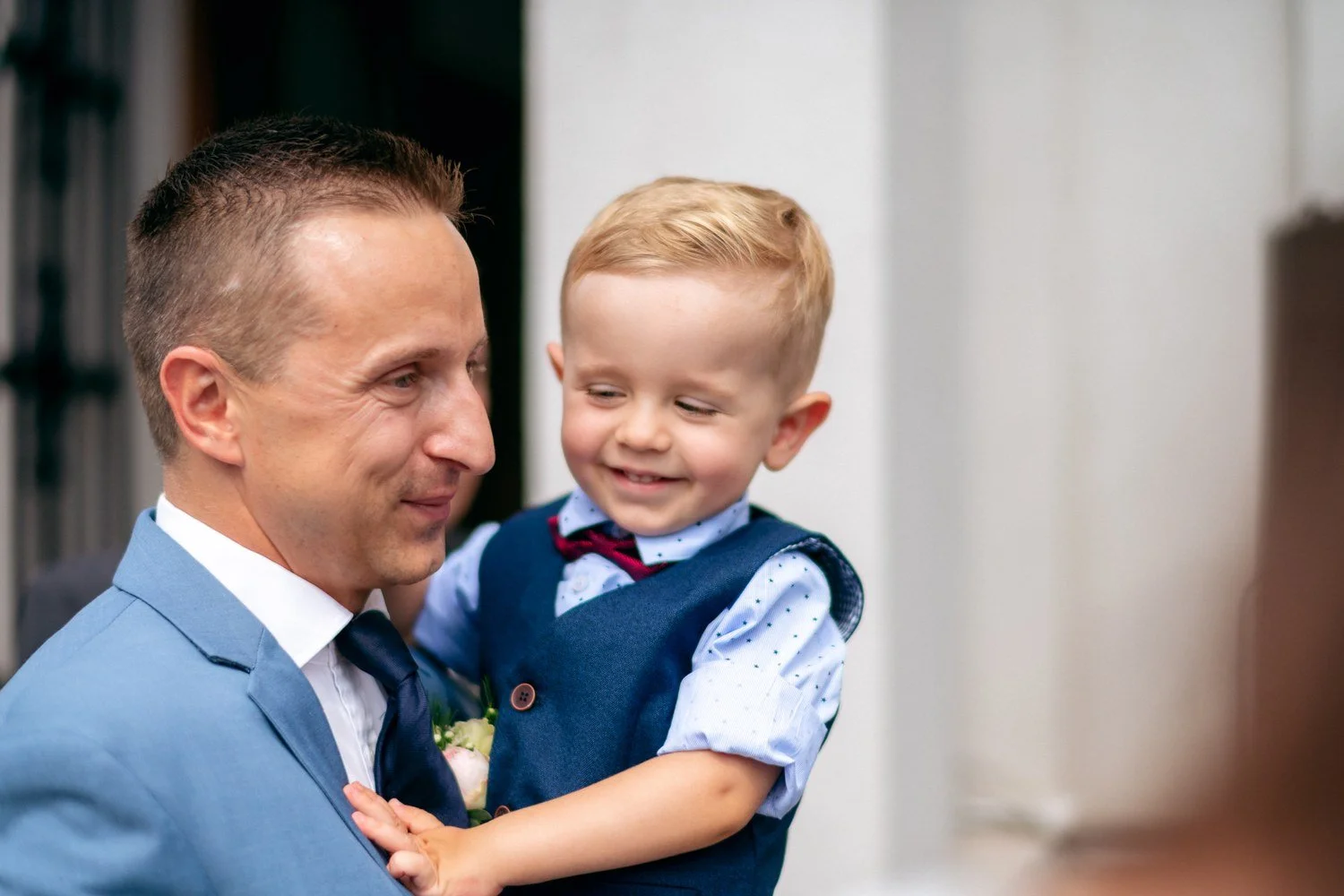 Radost ženicha s malým chlapcem přináší bezprostřední vztahový moment a změnu měřítka.
