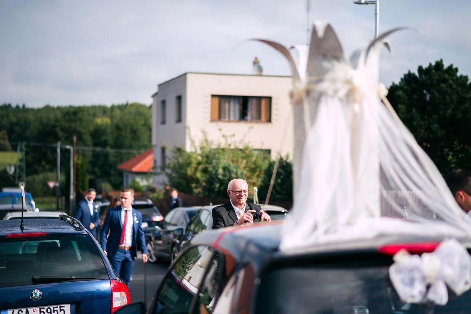 Dlouhá bílá sukně splývá přes zadní část auta.
