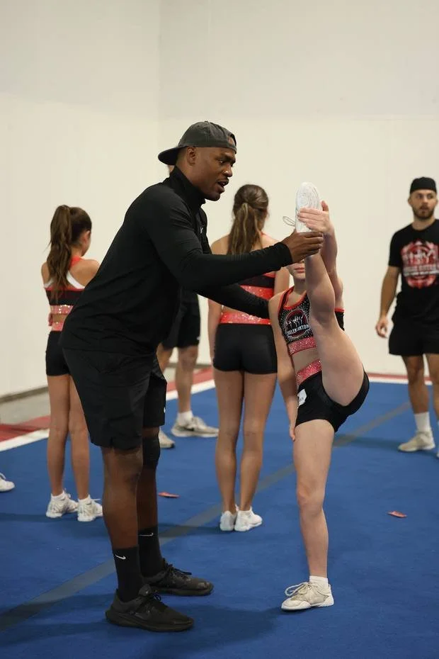 Coach Malek giving live feedback on a flyer’s body position