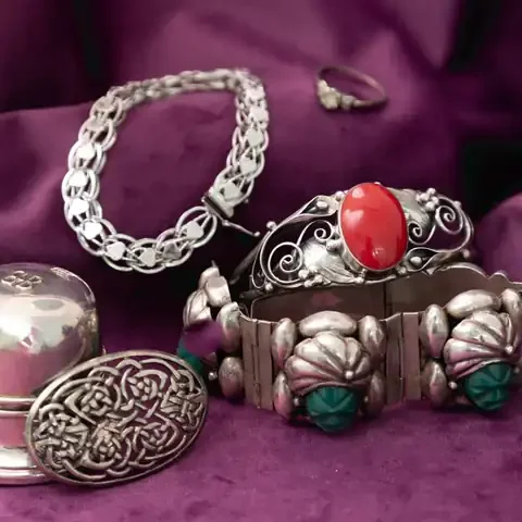 Sterling silver bracelets, a Celtic brooch, a ring and a small silver box on purple velvet