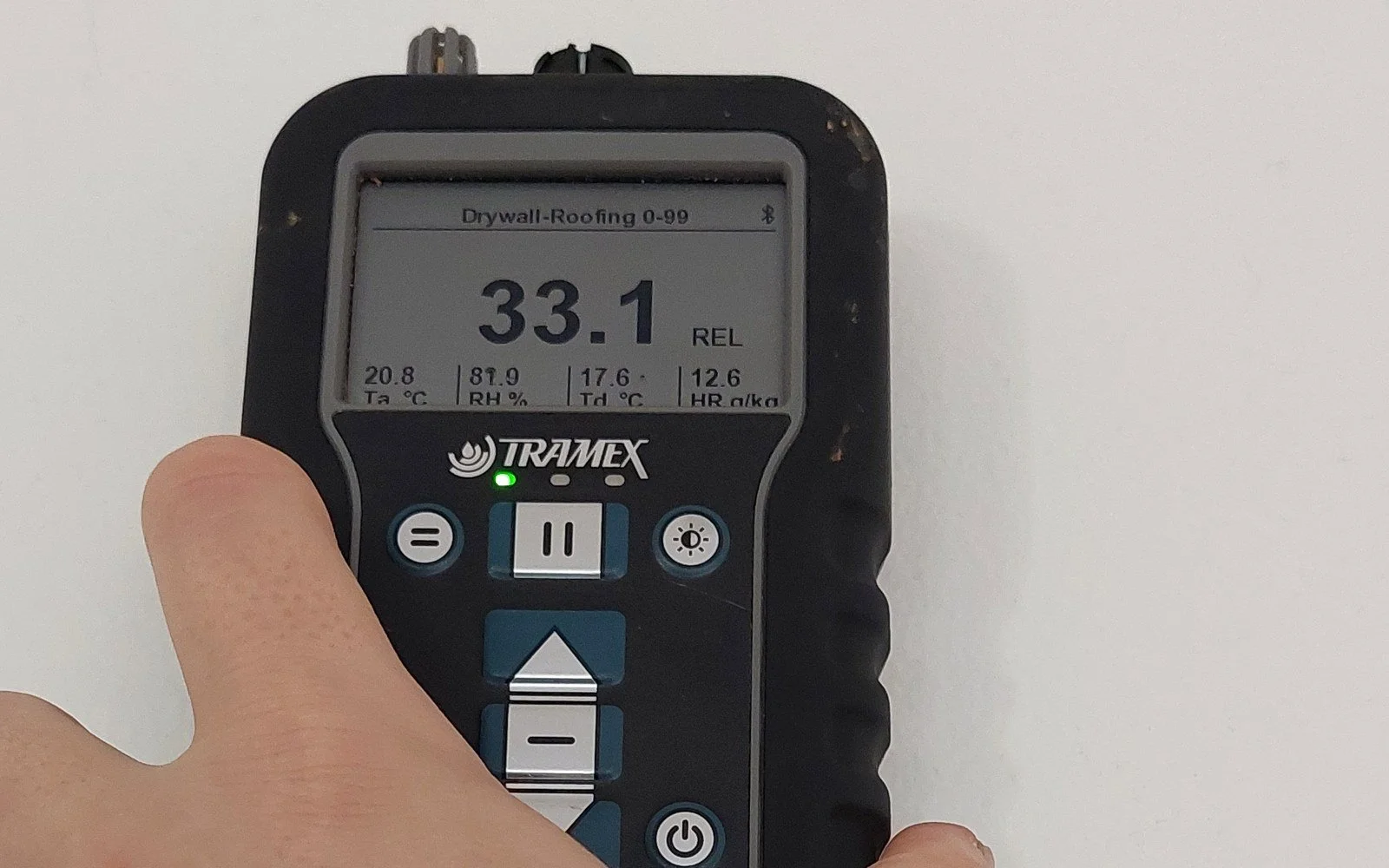 A moisture meter showing a relative reading on a wall