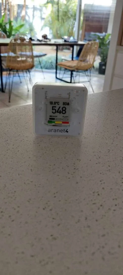 Environmental monitor on a bench in a living area.