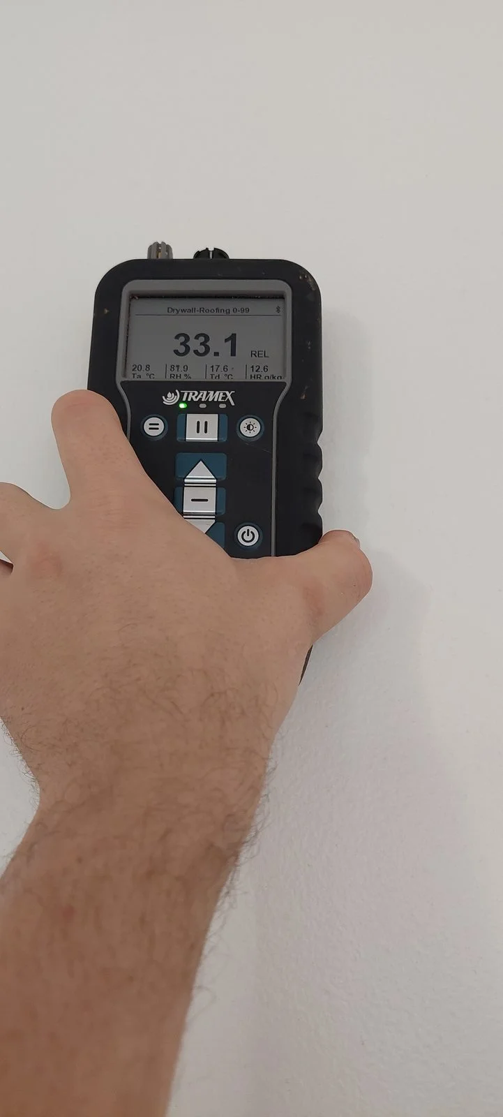 Non-invasive moisture-indicator reading being taken on a wet-area wall.