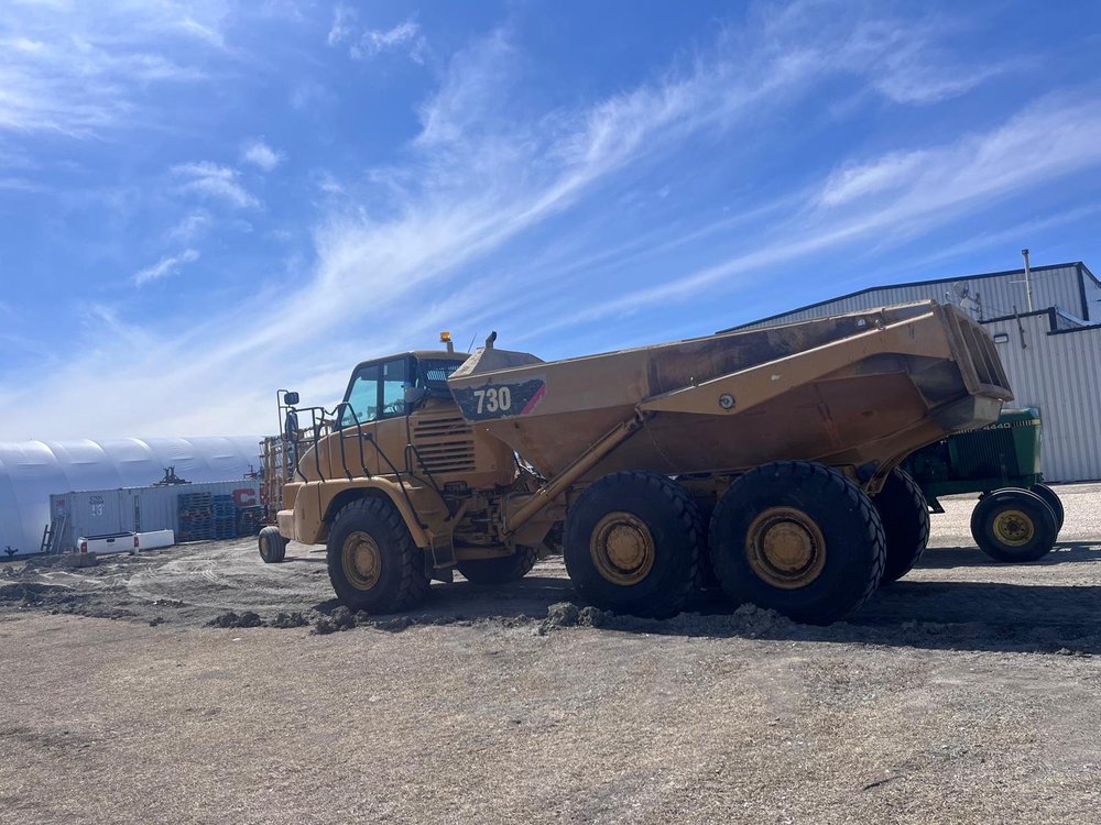 Cat 730 articulated dump truck with worn paint before restoration