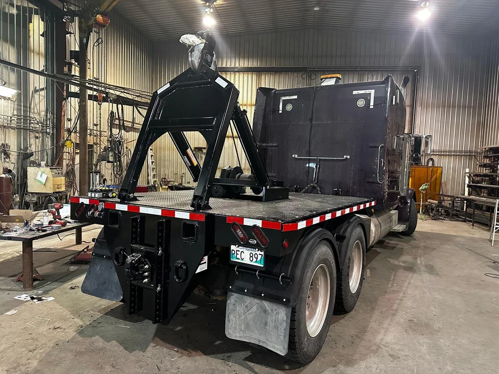 Truck with a steel lifting frame mounted on the back inside the Klassen Repair Shop