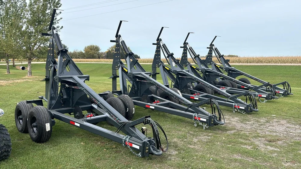 Row of five finished dark grey mole plows lined up on the grass